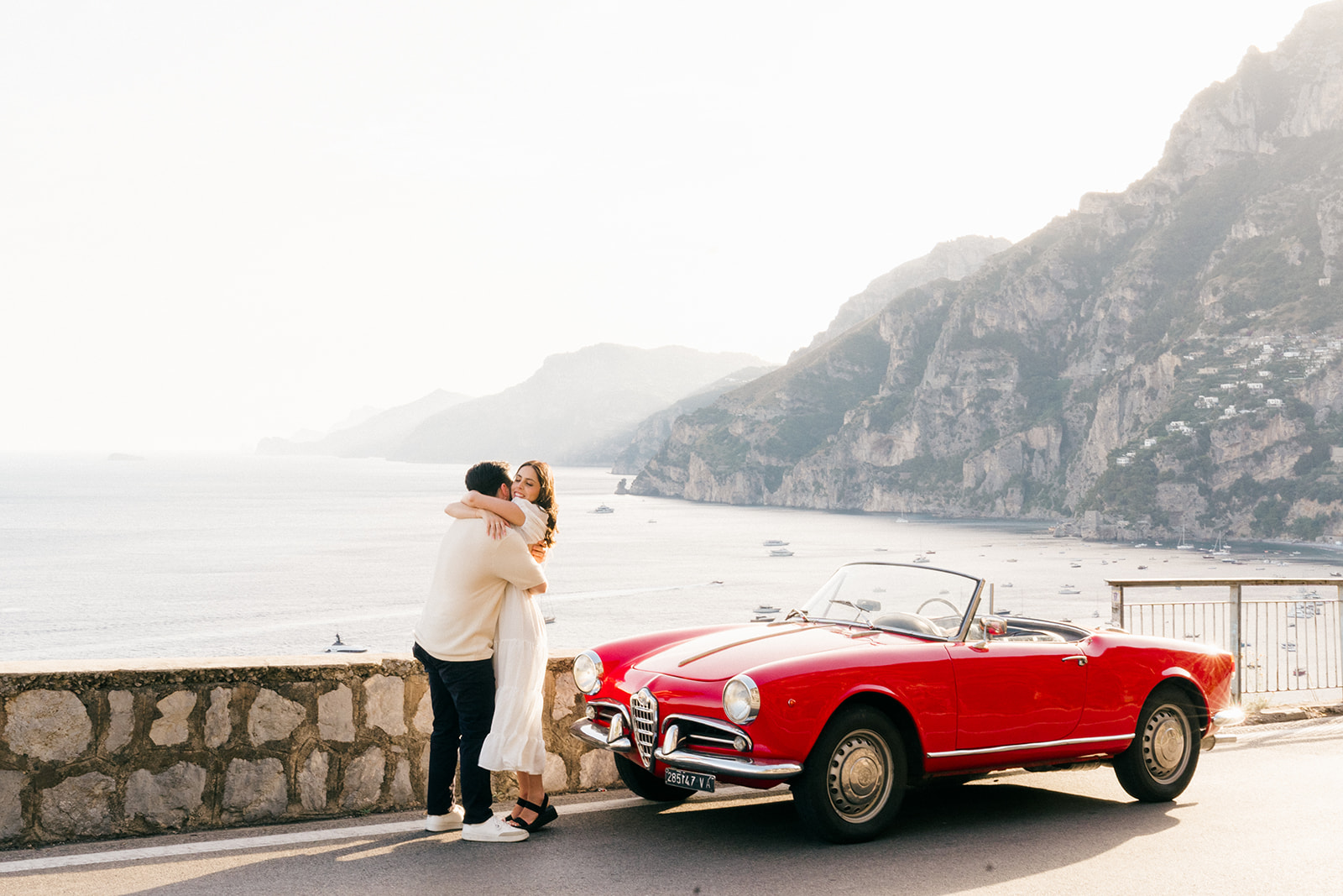 happy couple hugging in Positano with an italian vintage car