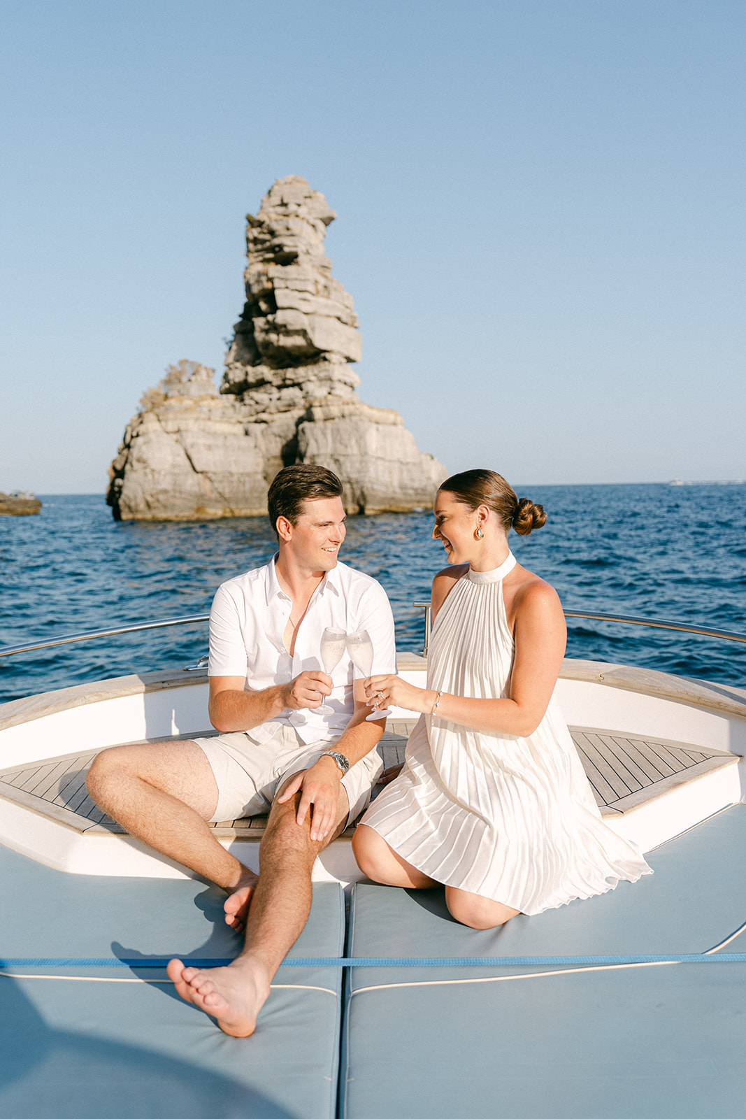 couple toast on a boat for their engagement photoshoot