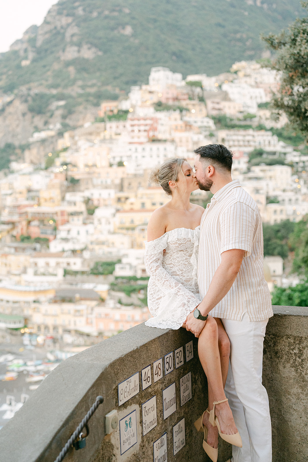 couple kissing with the view of Positano