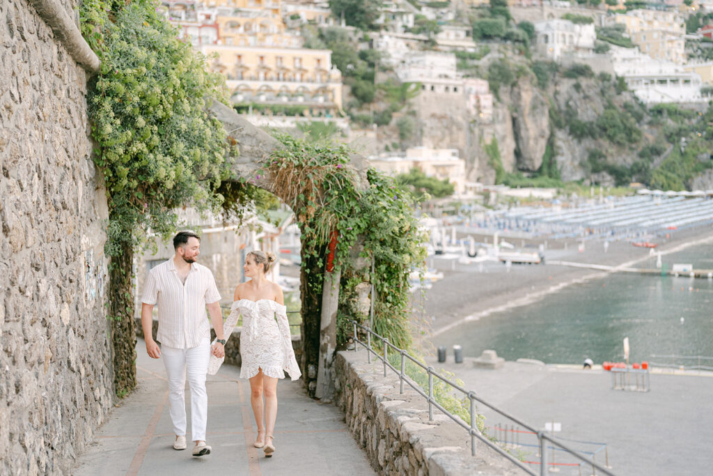 couple holding hands walking in Positano