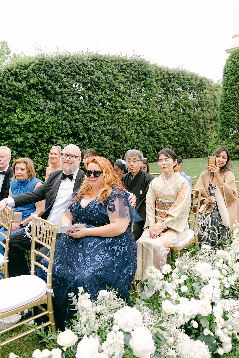 photo of the wedding guests during wedding ceremony, smiling and happy