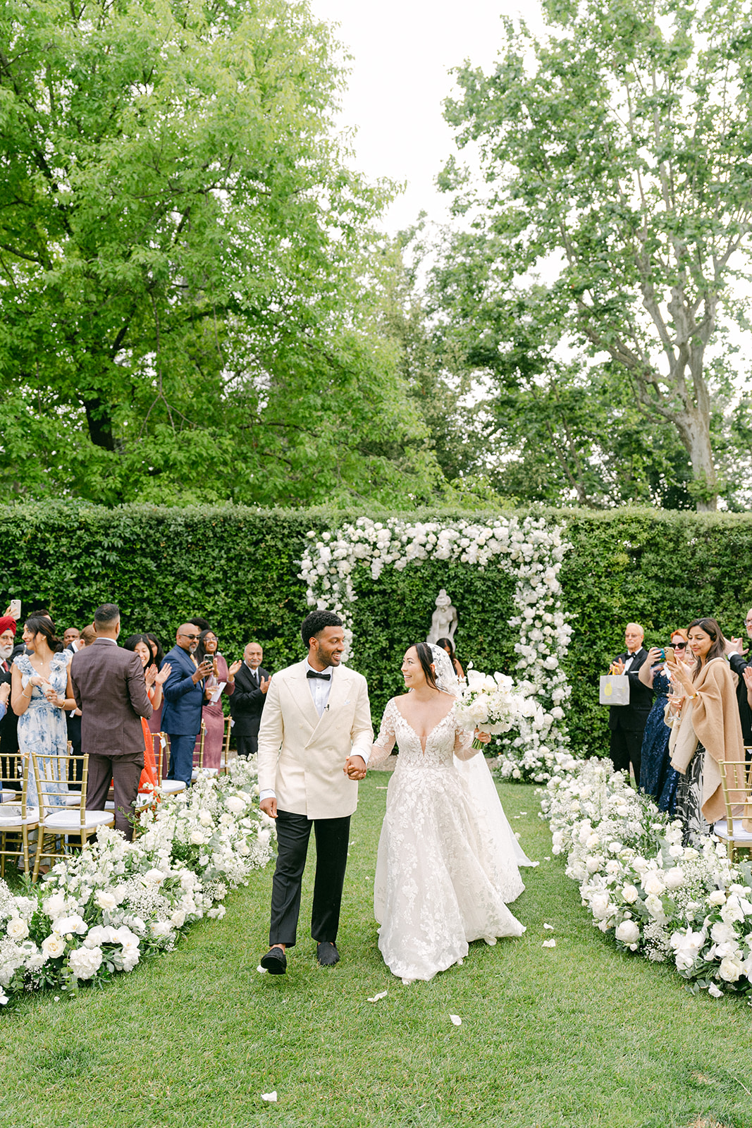 An intimate wedding ceremony in Villa Cora, Tuscany with beautiful white wedding flowers for the wedding aisle and wedding arch