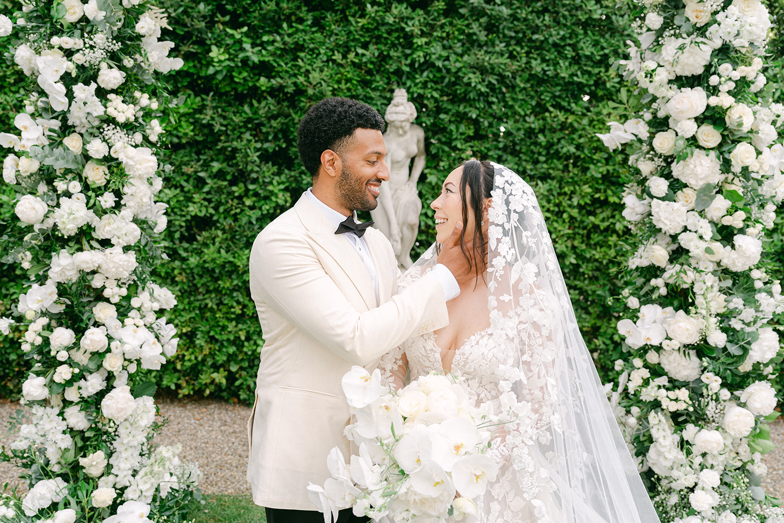 a candid wedding photo of the groom holding on to the bride's face during wedding ceremony