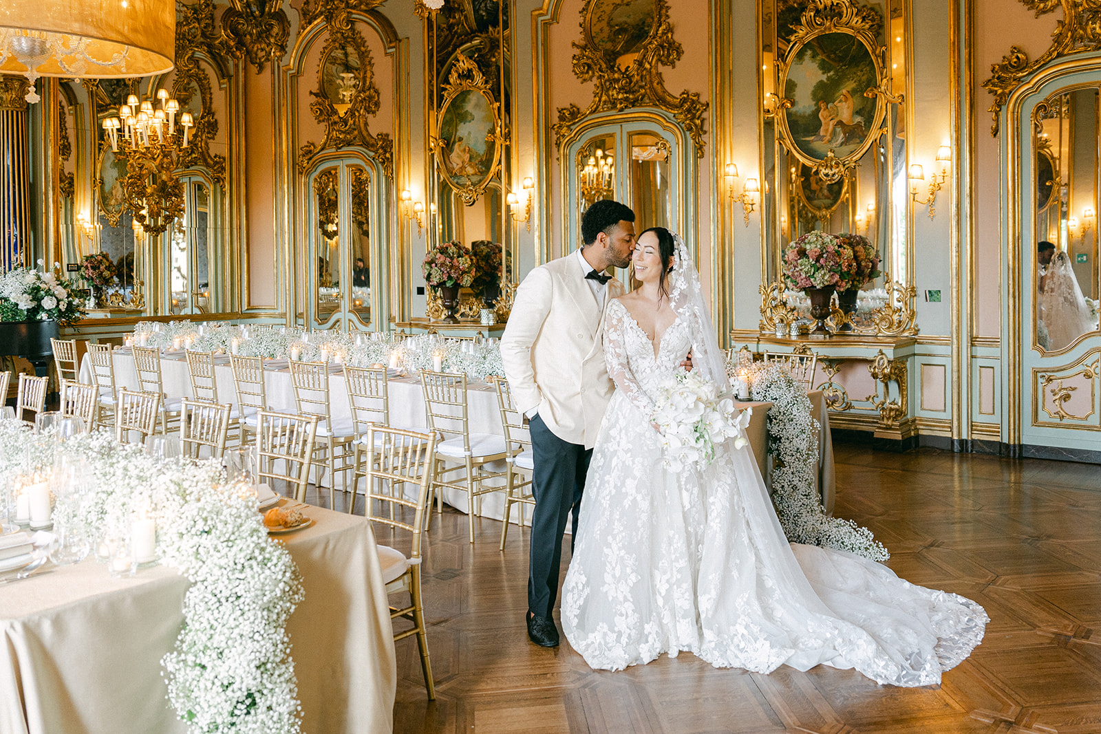groom kissing the bride not he cheek in the elegant wedding reception room