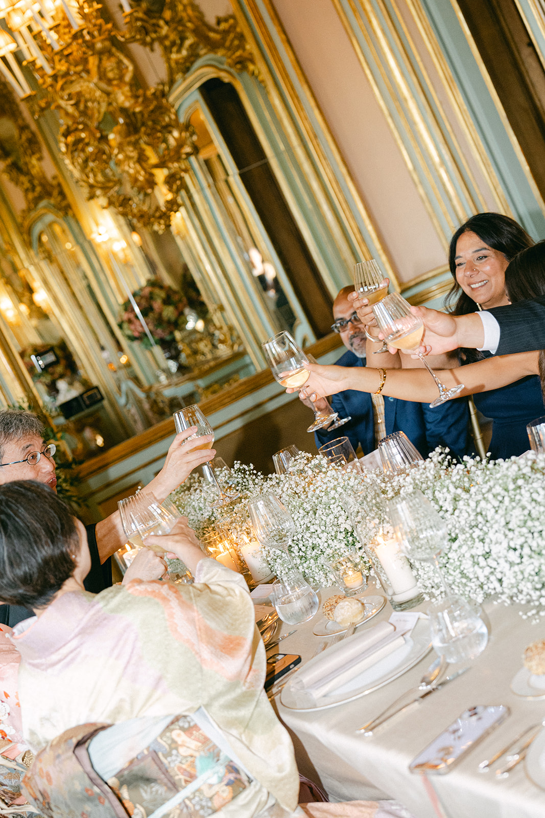 a candid wedding photo of the wedding guests toasting during wedding reception