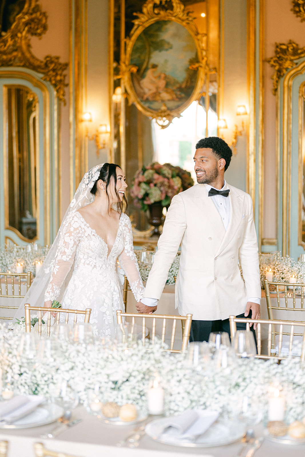 bride and groom walking through their luxury wedding reception table setting