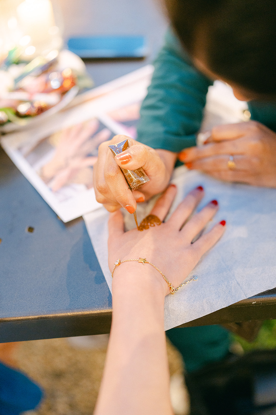 an Artist doing henna for a wedidng guest