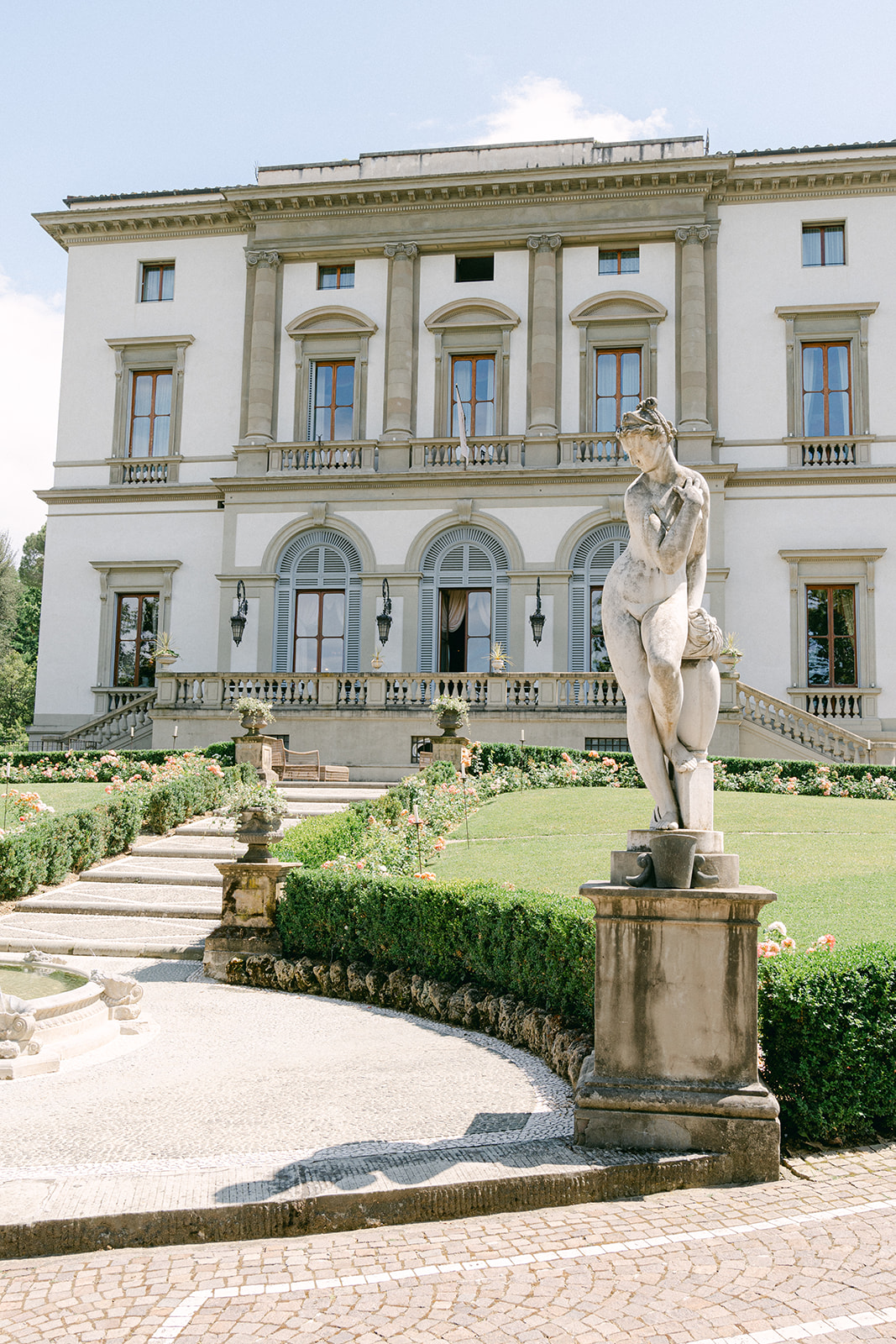 outdoor view of Villa Cora, the building and the garden with a statue
