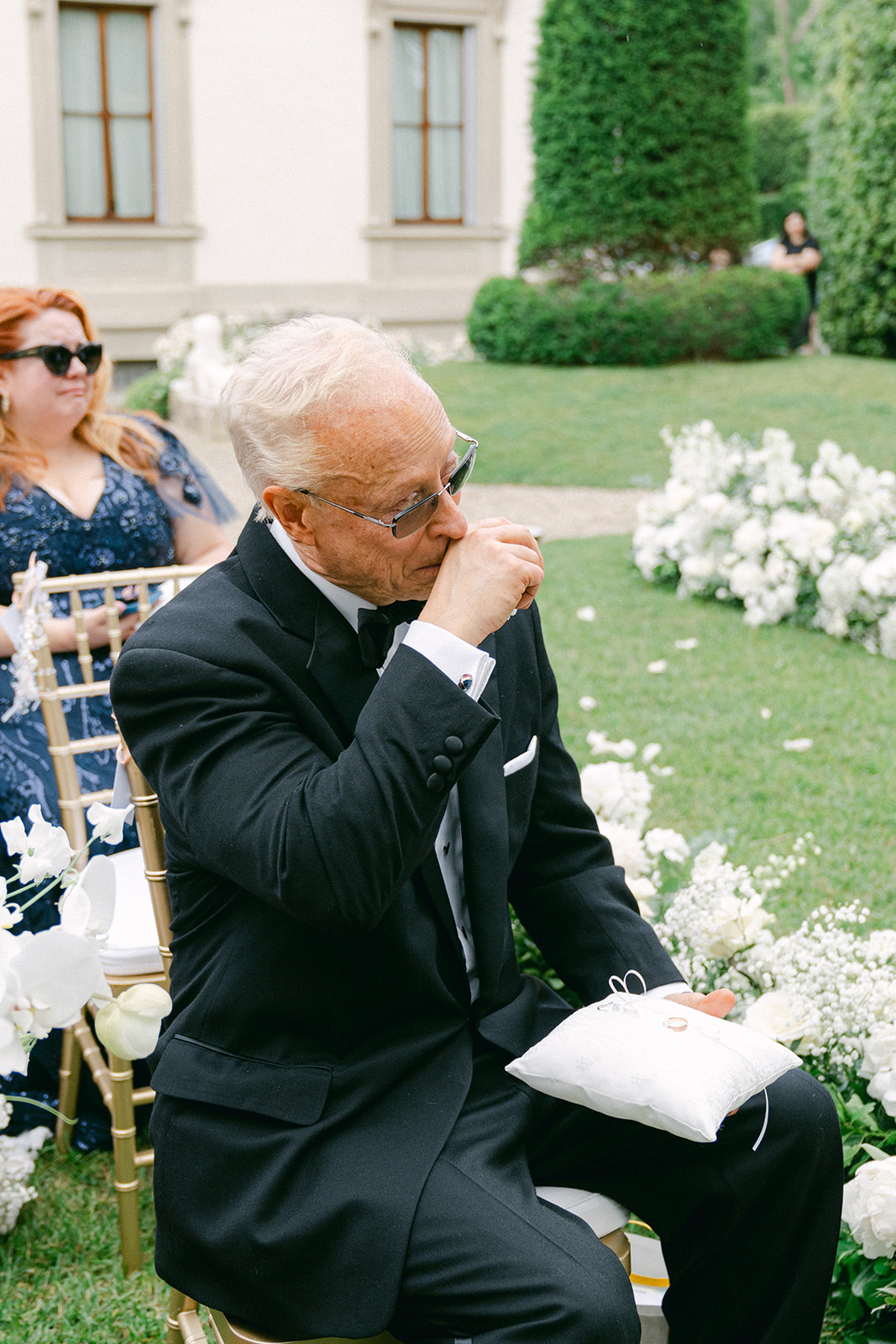 a candid wedding photo of the father of the bride getting emotional during wedding ceremony 