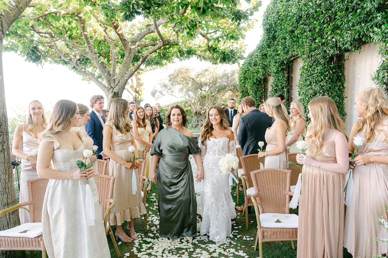 bride and mother of the bride walking in the wedding ceremony aisle