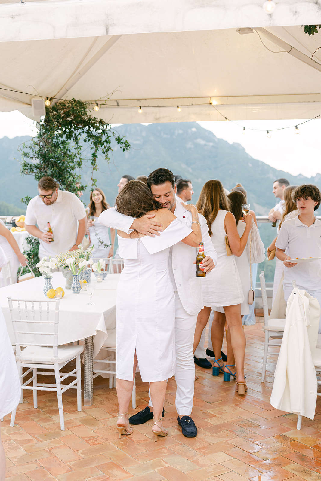 documentary wedding photo of groom hugging guest