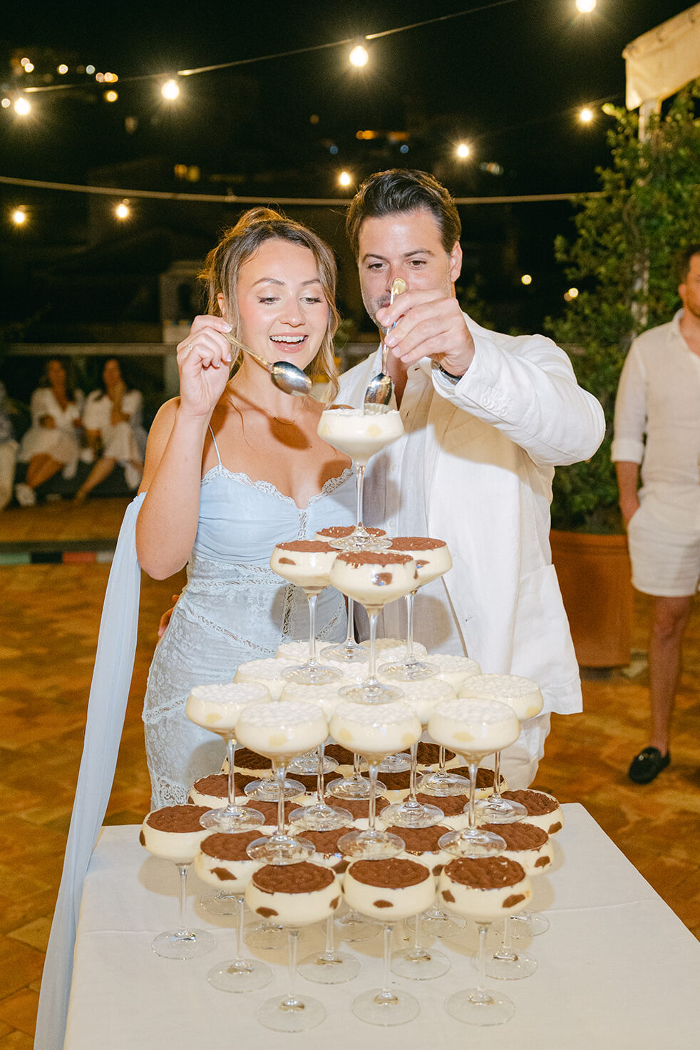 bride and groom digging in their tiramisu tower