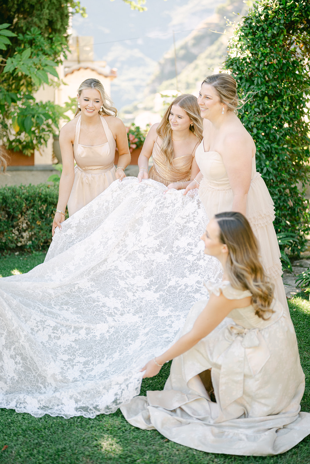 the bridesmaids holding the bride's dress