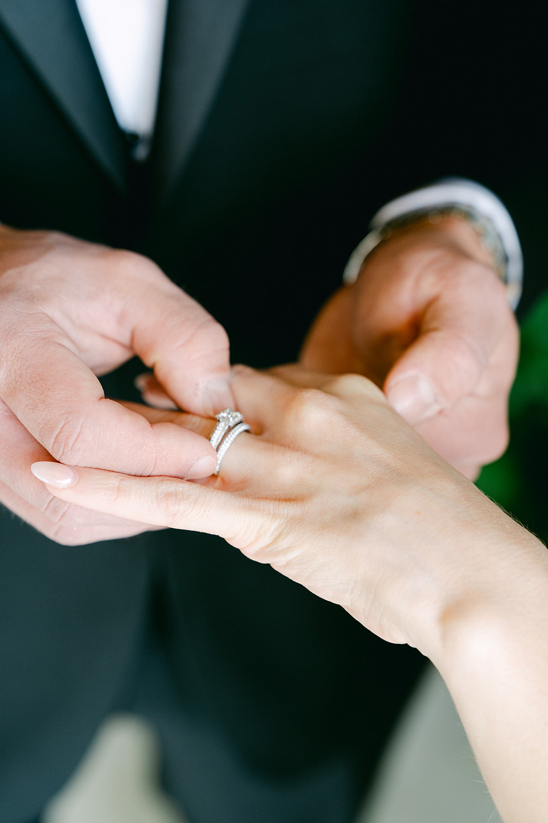 groom putting the ring on the bride