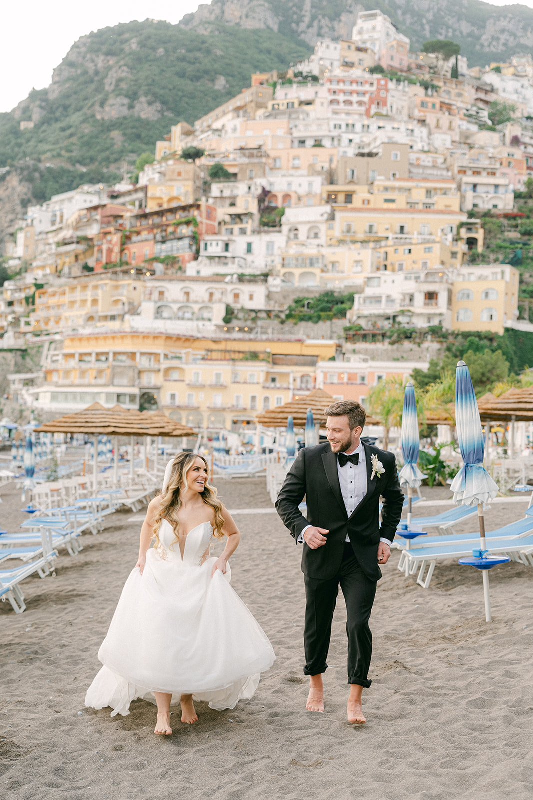 bride and groom running in the Positano beach 