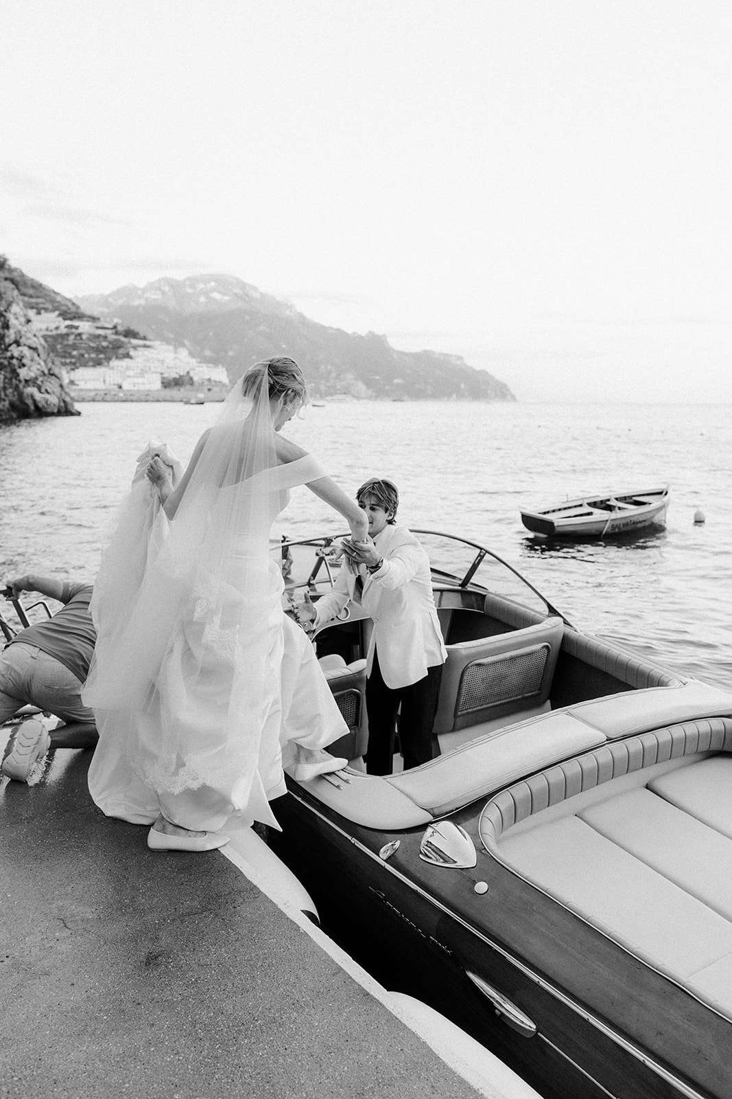 Andrea Gallucci - Destination Wedding Photographer- Amalfi Coast Positano Santorini Barcellona Rome Ravello Paris New York Bride and groom on a luxury yacht after their wedding on the Amalfi Coast, enjoying a private boat ride with ocean views and romantic Italian scenery.