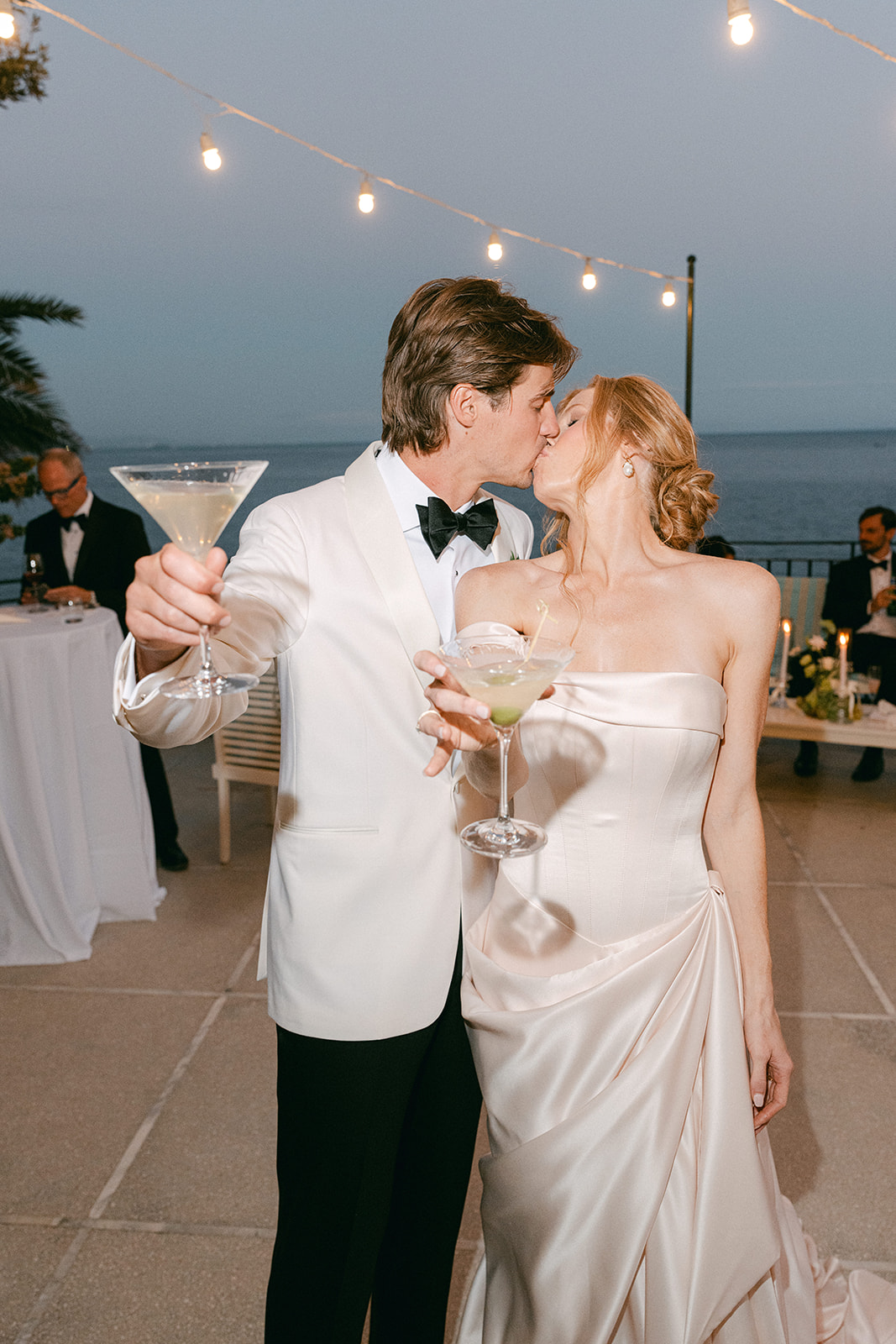Andrea Gallucci - Destination Wedding Photographer- Amalfi Coast Positano Santorini Barcellona Rome Ravello Paris New York Couple pouring martinis into a modern martini tower at their wedding.
