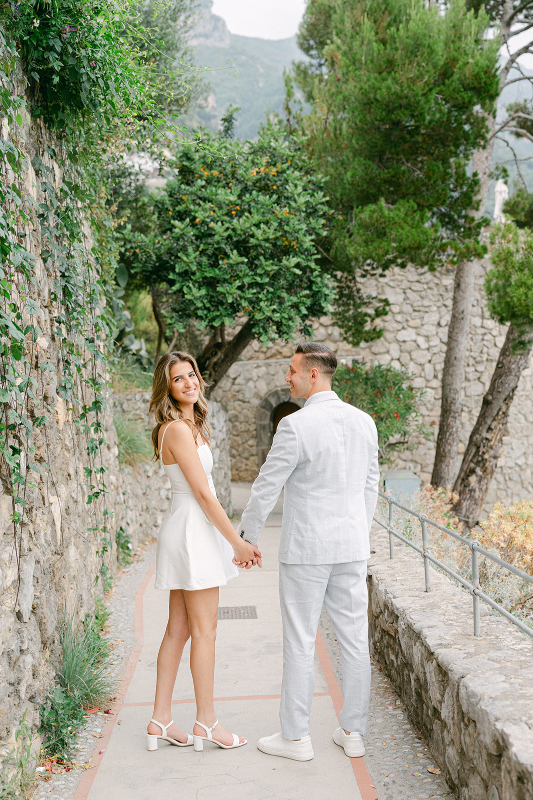 Andrea Gallucci - Destination Wedding Photographer- Amalfi Coast Positano Santorini Barcellona Rome Ravello Paris New York Couple walking through Positano streets during Amalfi Coast vacation engagement photos