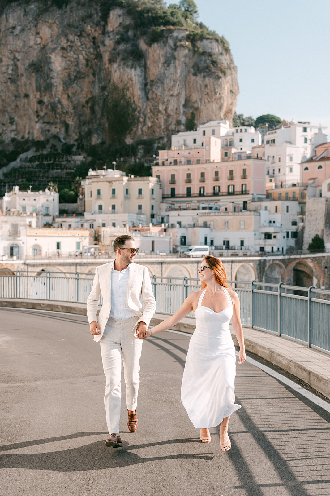 Andrea Gallucci - Destination Wedding Photographer- Amalfi Coast Positano Santorini Barcellona Rome Ravello Paris New York Bride and groom walking along the Amalfi Coast cliffs during engagement photos